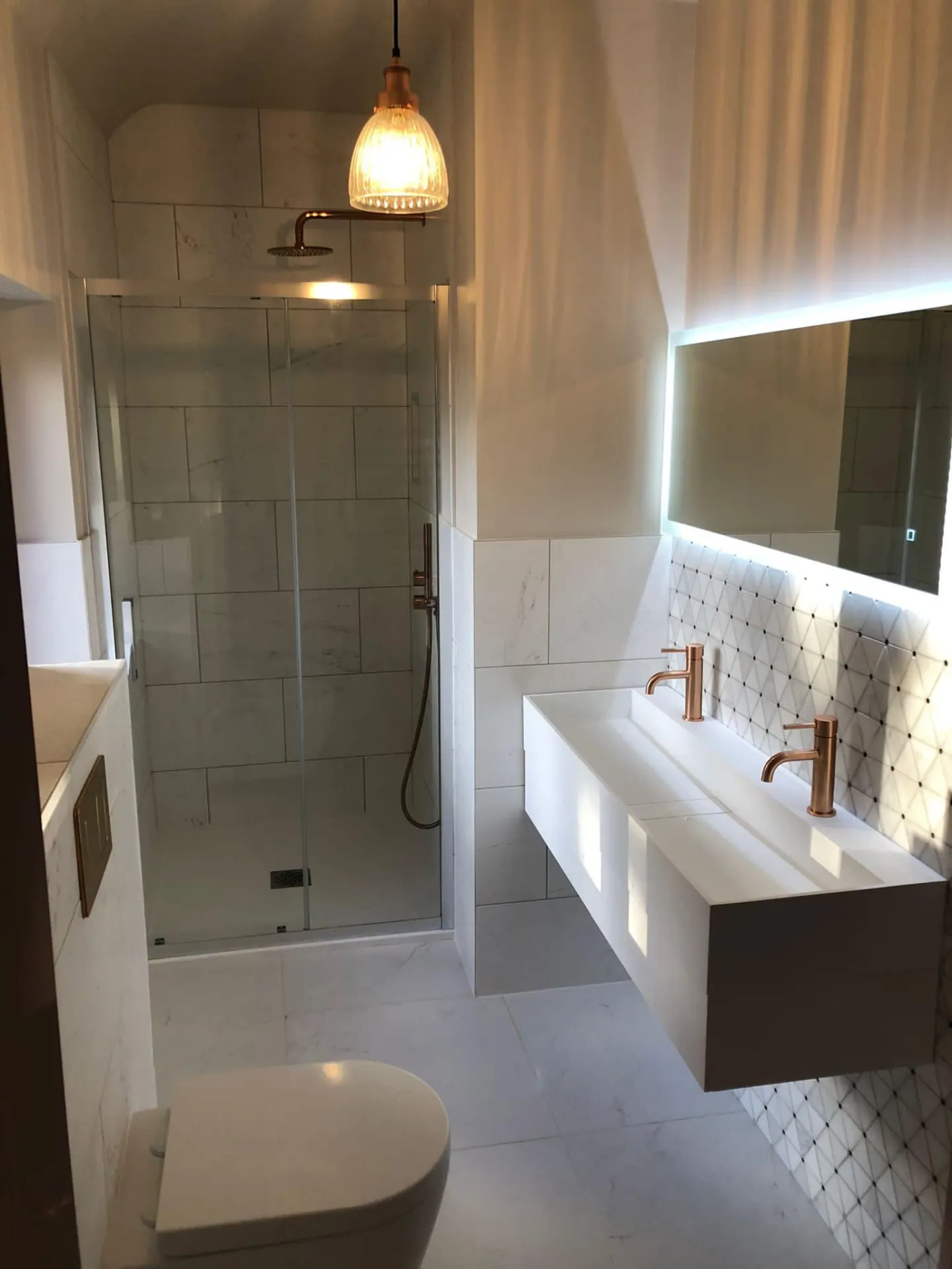 Marble-tiled his-and-hers en suite created during a full house remodel by JRC Developers, builders in Henley-in-Arden, Worcestershire
